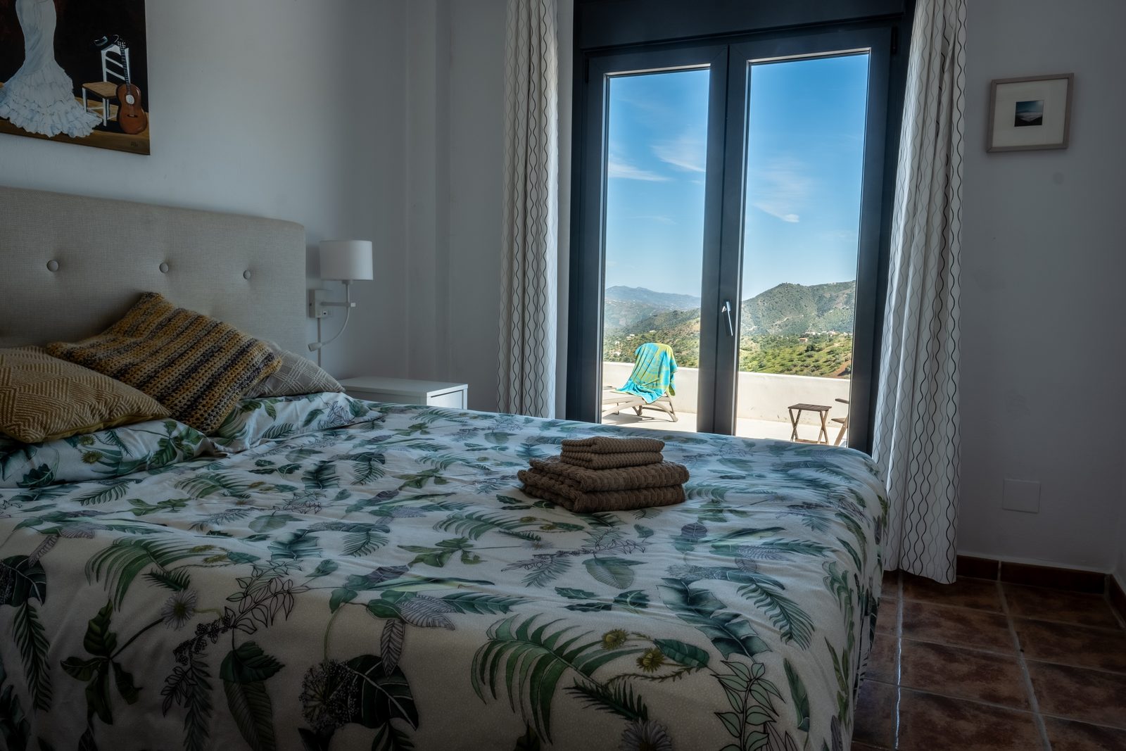 Master bedroom met openslaande deuren naar het terras en uitzicht op de vallei
